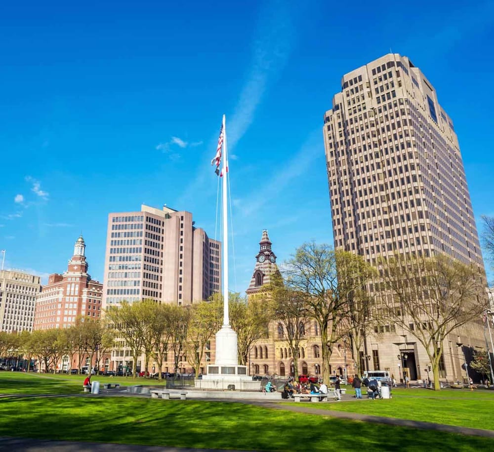 Vibrant cityscape of downtown with modern skyscrapers and historic buildings on a sunny day.