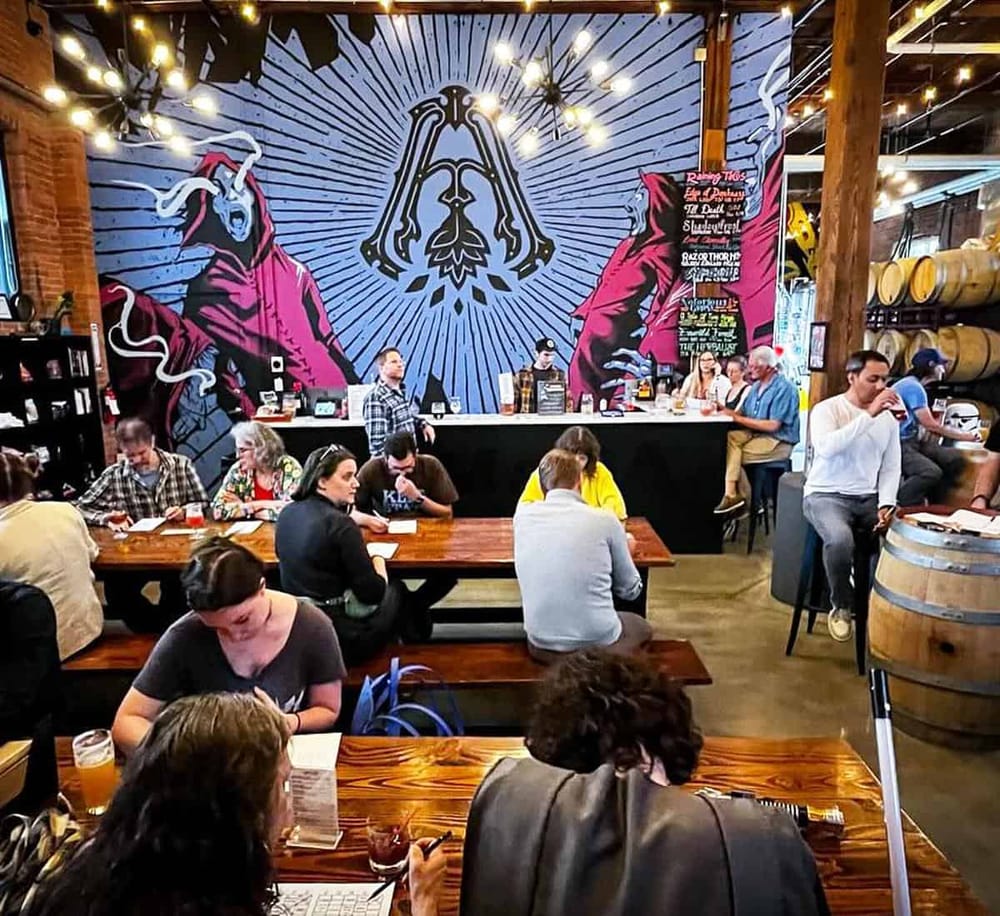 Vibrant brewery interior with colorful murals, patrons enjoying drinks, and rustic decor at QuestForDirections.