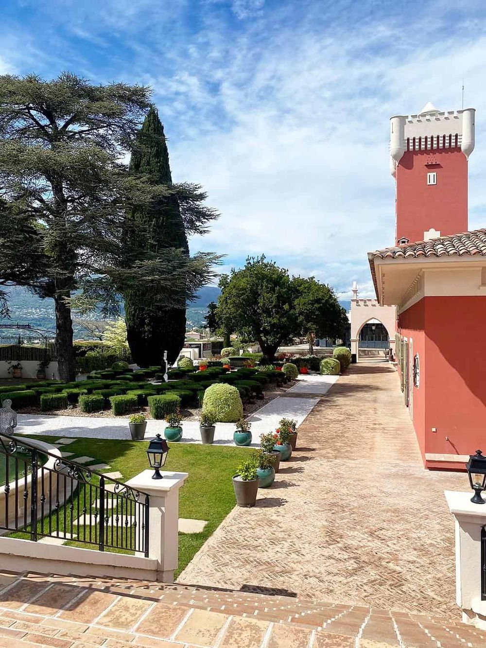 Elegant garden with ornate landscaping and a castle tower, perfect for luxury wedding venues and scenic event locations.