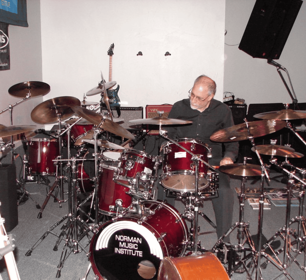 Dynamic image of a drummer playing at Norman Music Institute, showcasing musical performance and band practice.