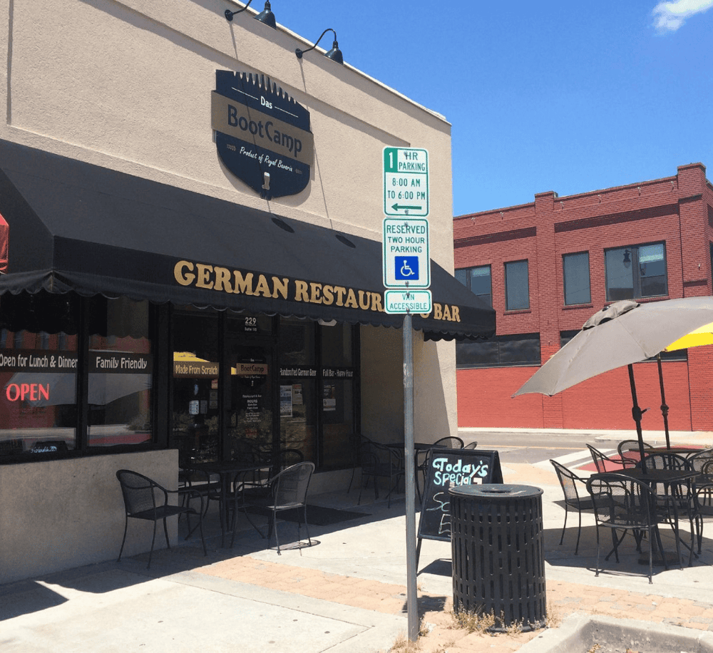 Outdoor German restaurant with seating, signage, and accessible parking, located in a vibrant city neighborhood.