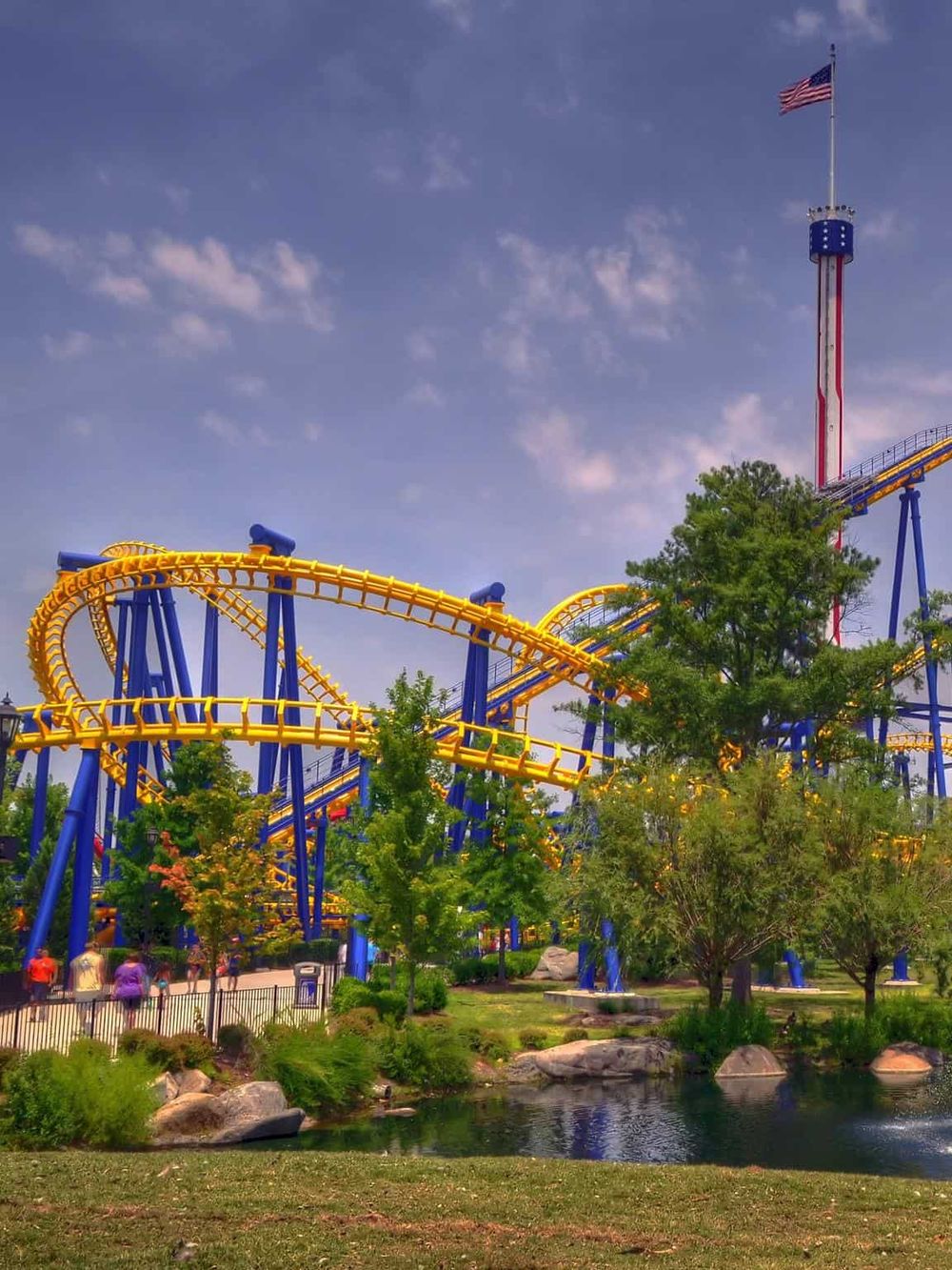 Thrilling roller coaster ride at Quest for Directions amusement park with vibrant yellow and blue tracks.