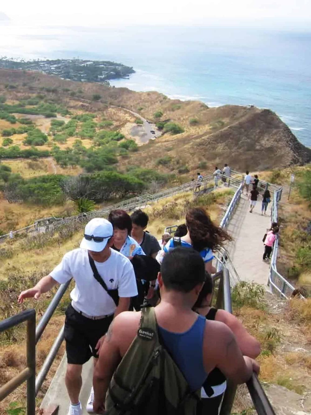 Scenic coastal hiking trail with tourists enjoying panoramic views and ocean scenery.