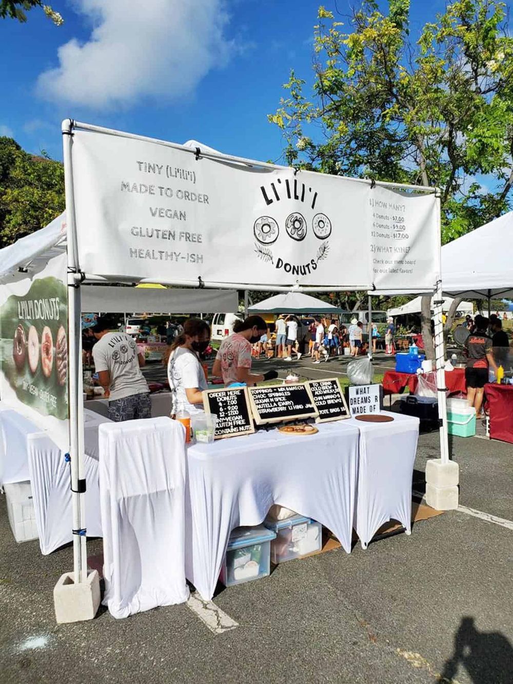 Delicious vegan donuts stand at outdoor market, emphasizing healthy, gluten-free dessert options.