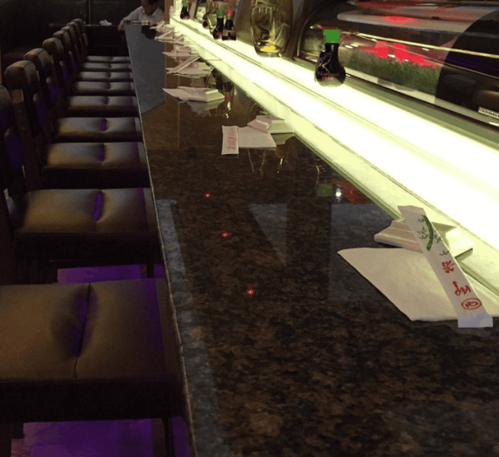 Elegant sushi bar with illuminated display case and seating at QuestForDirections.