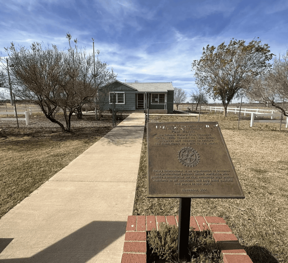 Vintage house plaque at the Odessa Rotary Club historic site, dedicated to community service and leadership.