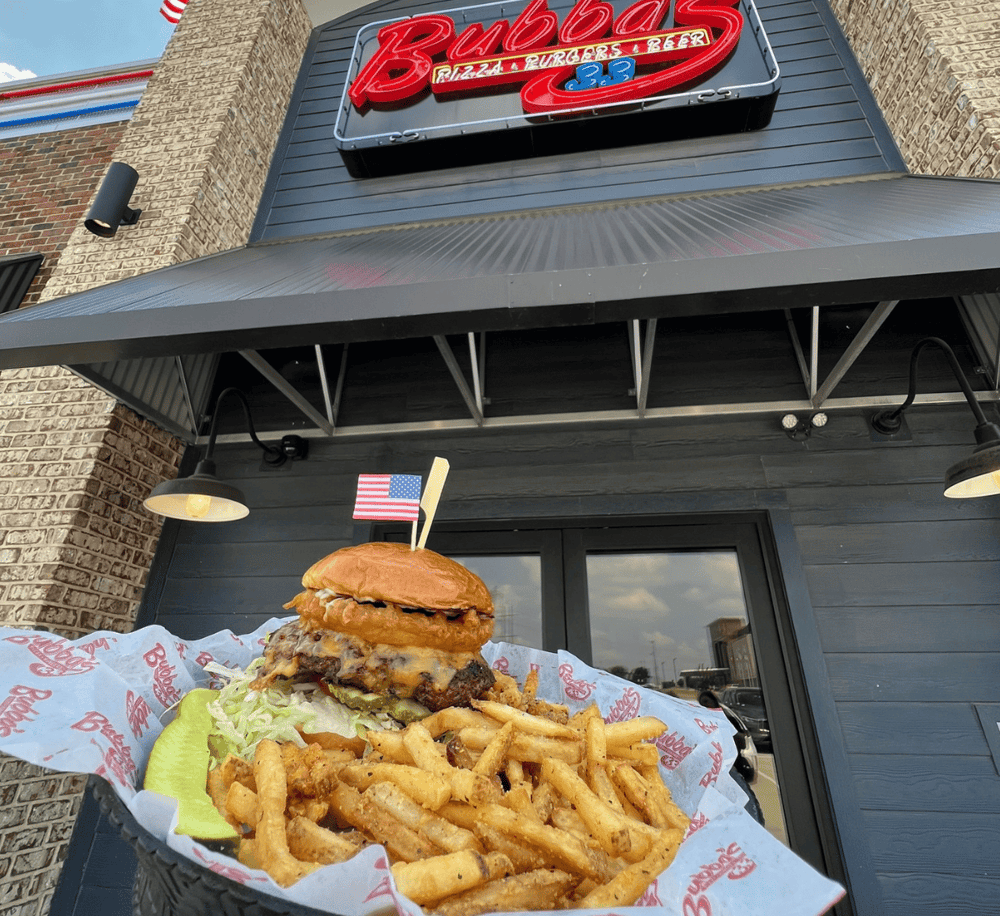Juicy cheeseburger with fries outside Bubba's restaurant, inviting American cuisine experience.