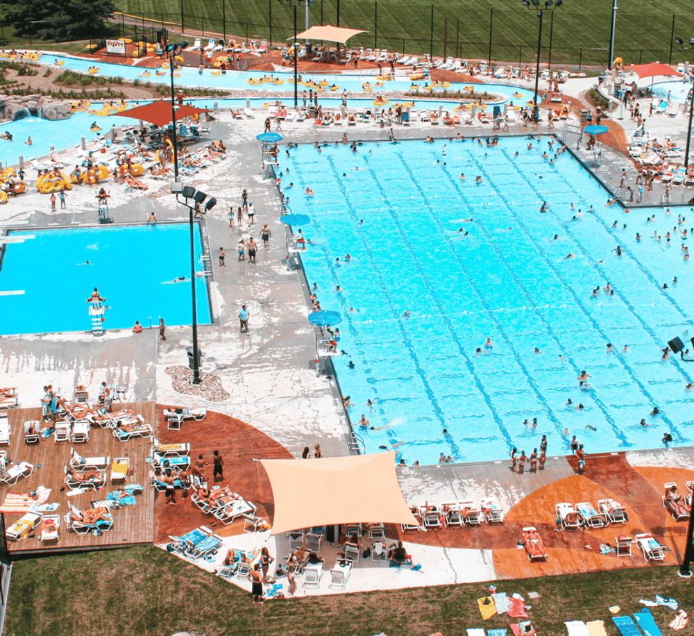 Overflowing public swimming pool with lounge chairs and umbrellas, summer fun at QuestForDirections.