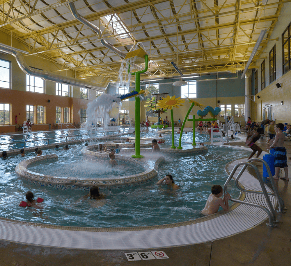 Vibrant indoor water park with kids enjoying water slides and splash stations, part of Quest for Directions.