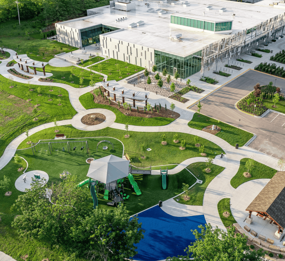 Bright aerial view of QuestForDirections campus with modern building and outdoor playground area.