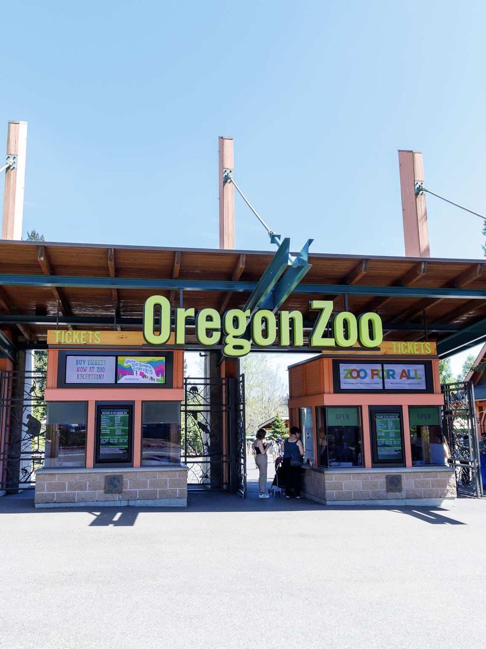 Colorful Oregon Zoo ticket booths at entrance with visitors, promoting family-friendly attractions and wildlife experiences.