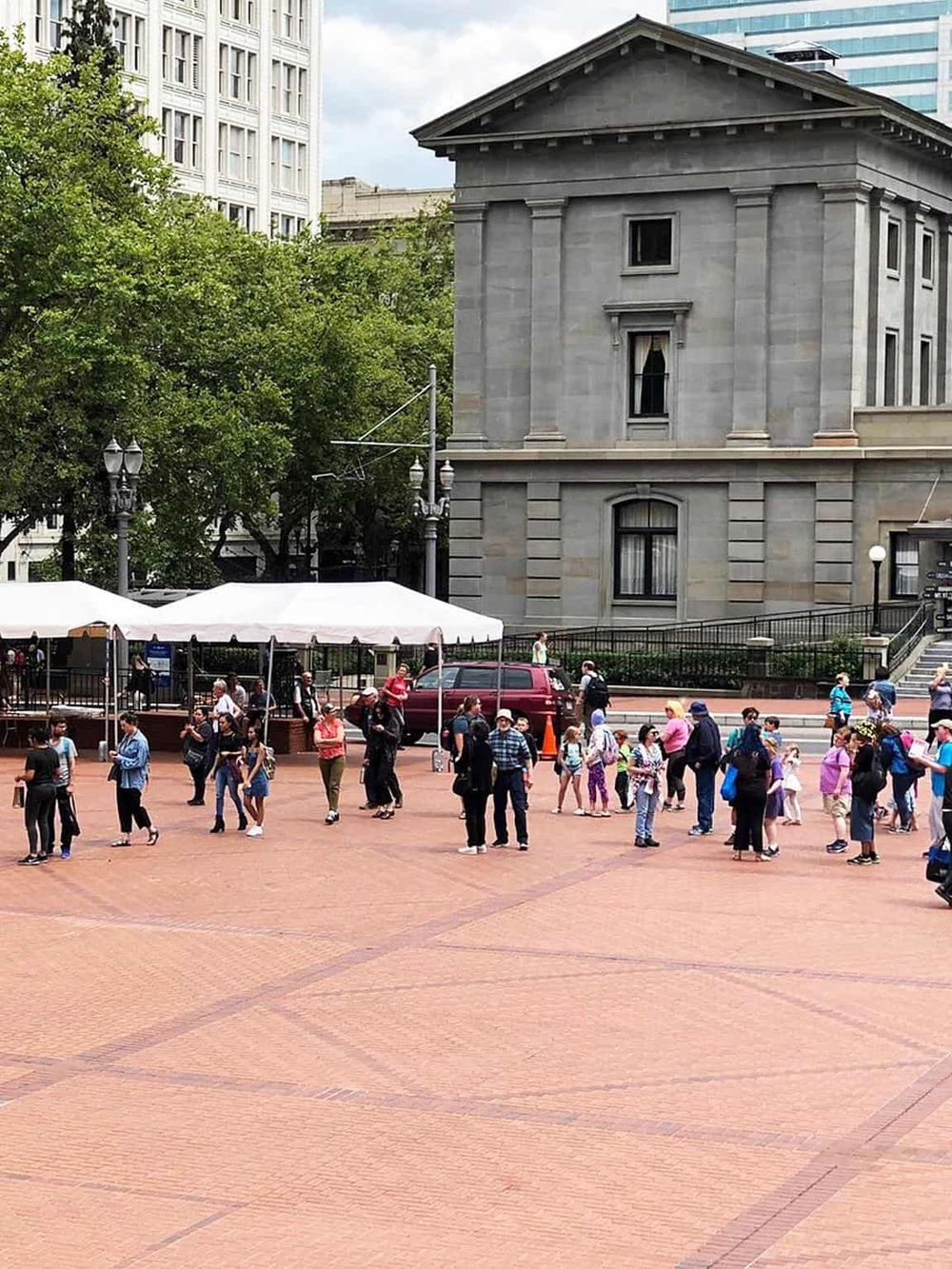 Crowd of tourists and travelers gathering at a historic city square with cityscape background, exploring local attractions.