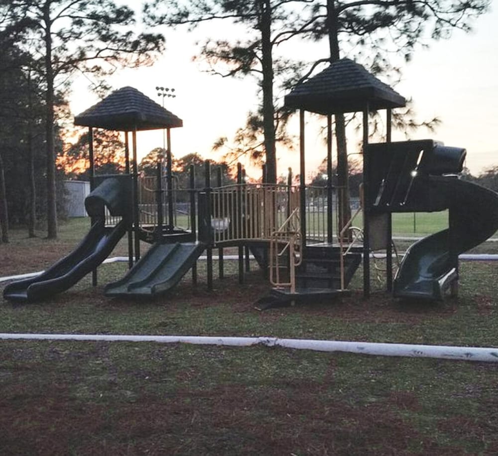 Colorful playground structure with slides and towers at sunset, ideal for children's outdoor activities and recreation.