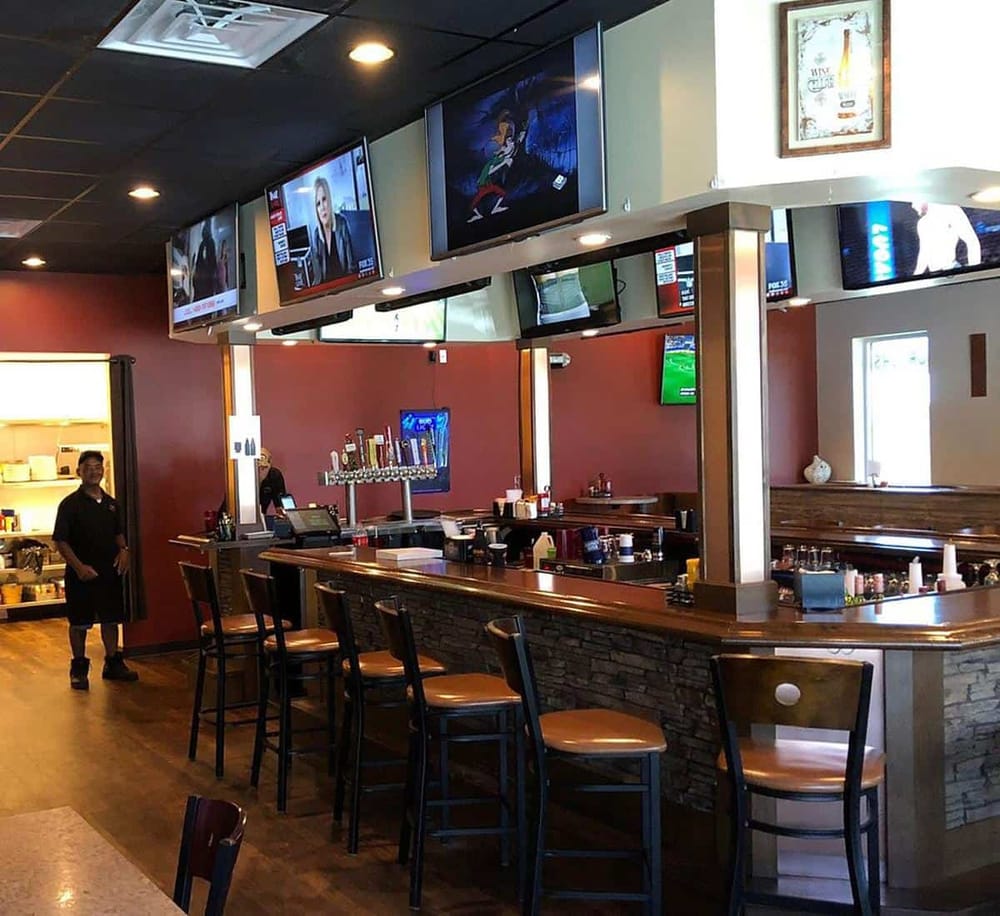 Bright sports bar with multiple TV screens, a well-stocked beer tap, and cozy seating for fans to enjoy live game coverage.