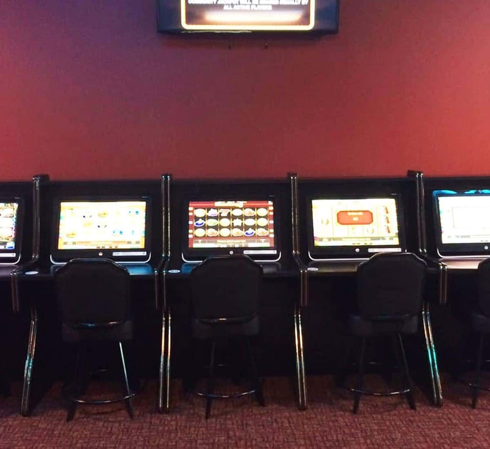 Bright casino slot machines with modern digital screens in a gaming lounge.