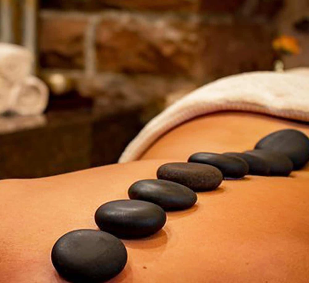 Hot stone massage therapy for relaxation and wellness in a spa setting.