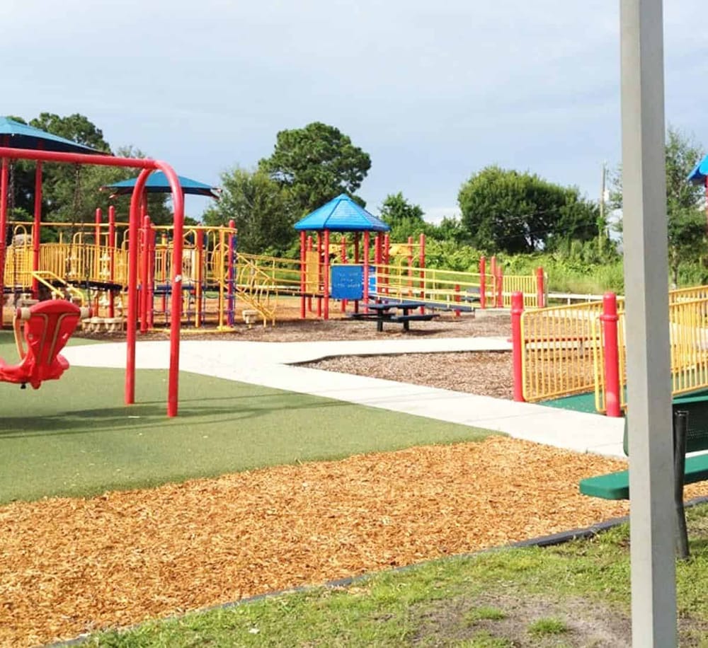 Colorful playground with slides, swings, and safety surfaces for children’s outdoor fun.