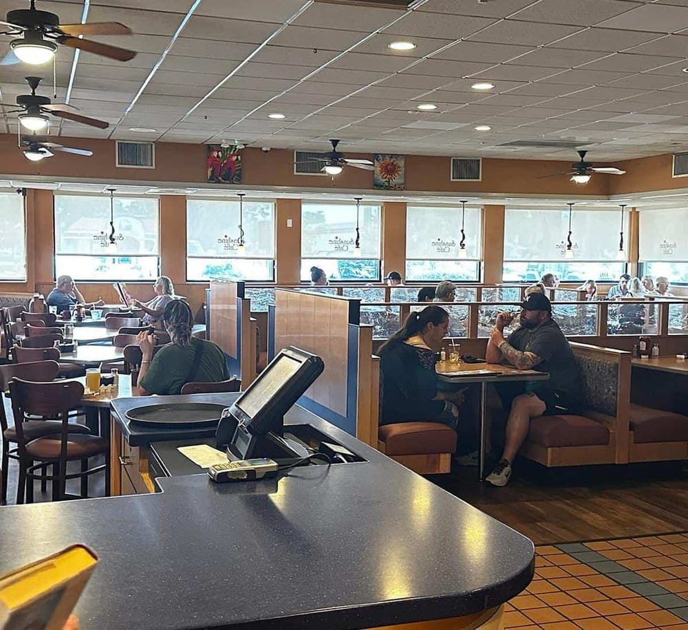 Bright, inviting restaurant interior with large windows, casual dining atmosphere, and diverse customers enjoying meals.