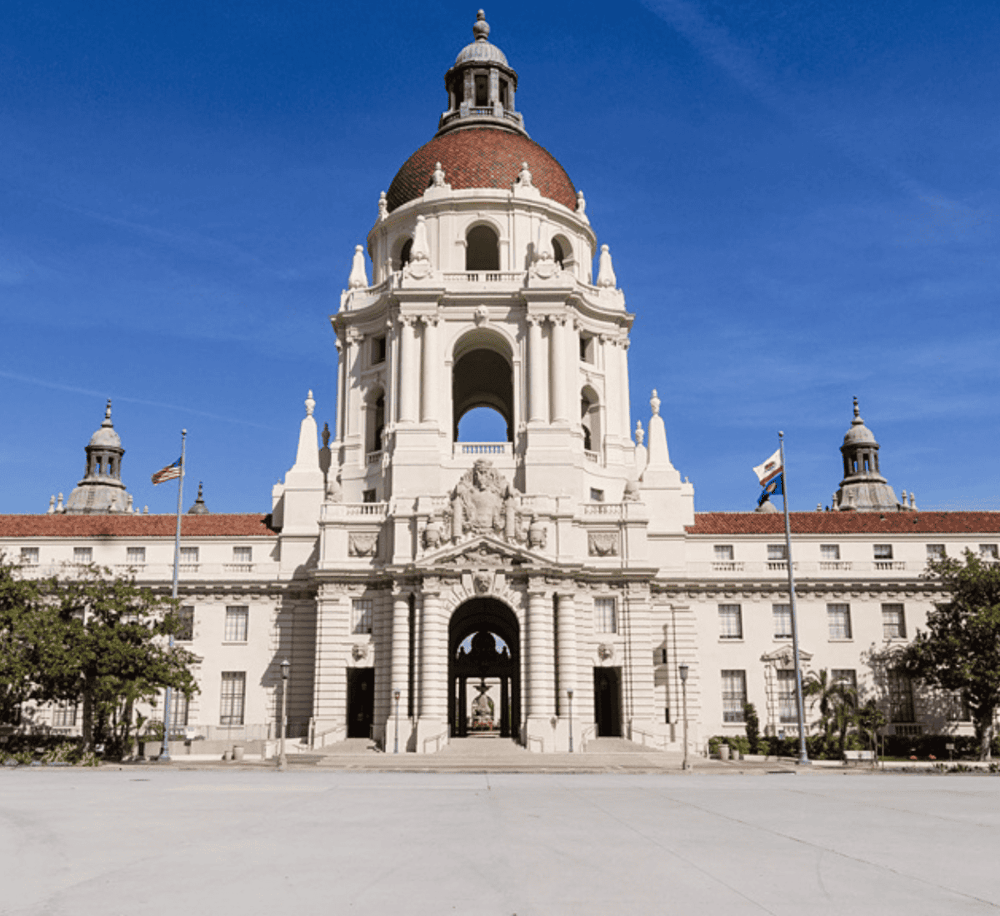 Grand California State Capitol building with white architecture and red dome, sunny blue sky background.