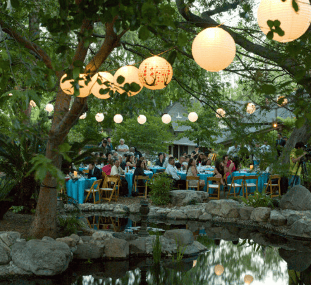 Lighted outdoor garden dining with paper lanterns at QuestForDirections.
