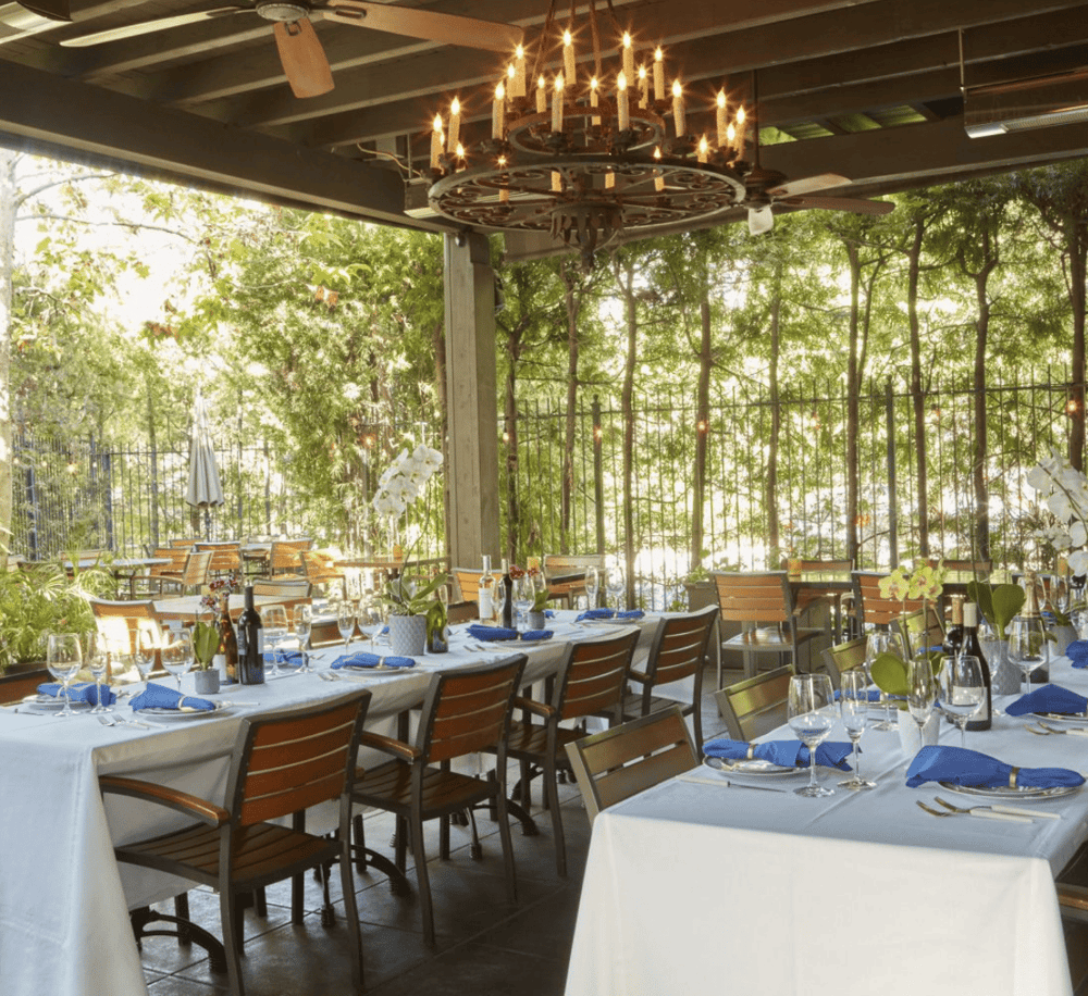 Elegant outdoor dining area with lush greenery and stylish decor for a memorable dining experience.