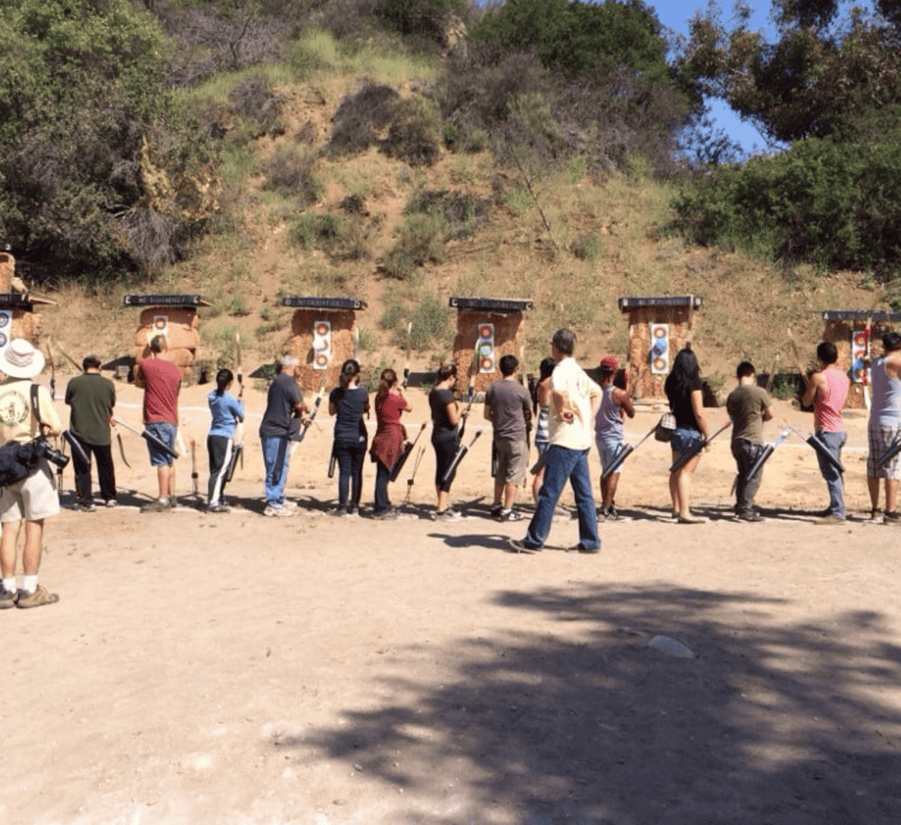 Archery range at outdoor shooting range with people practicing archery.