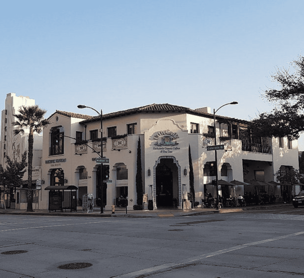 Charming Spanish-style building with outdoor dining, located on a busy street corner in downtown.