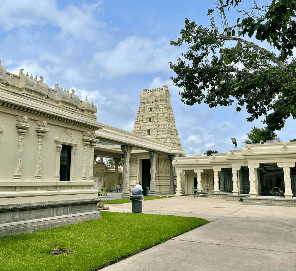 Ancient Hindu temple with intricate carvings and modern surroundings in Texas.
