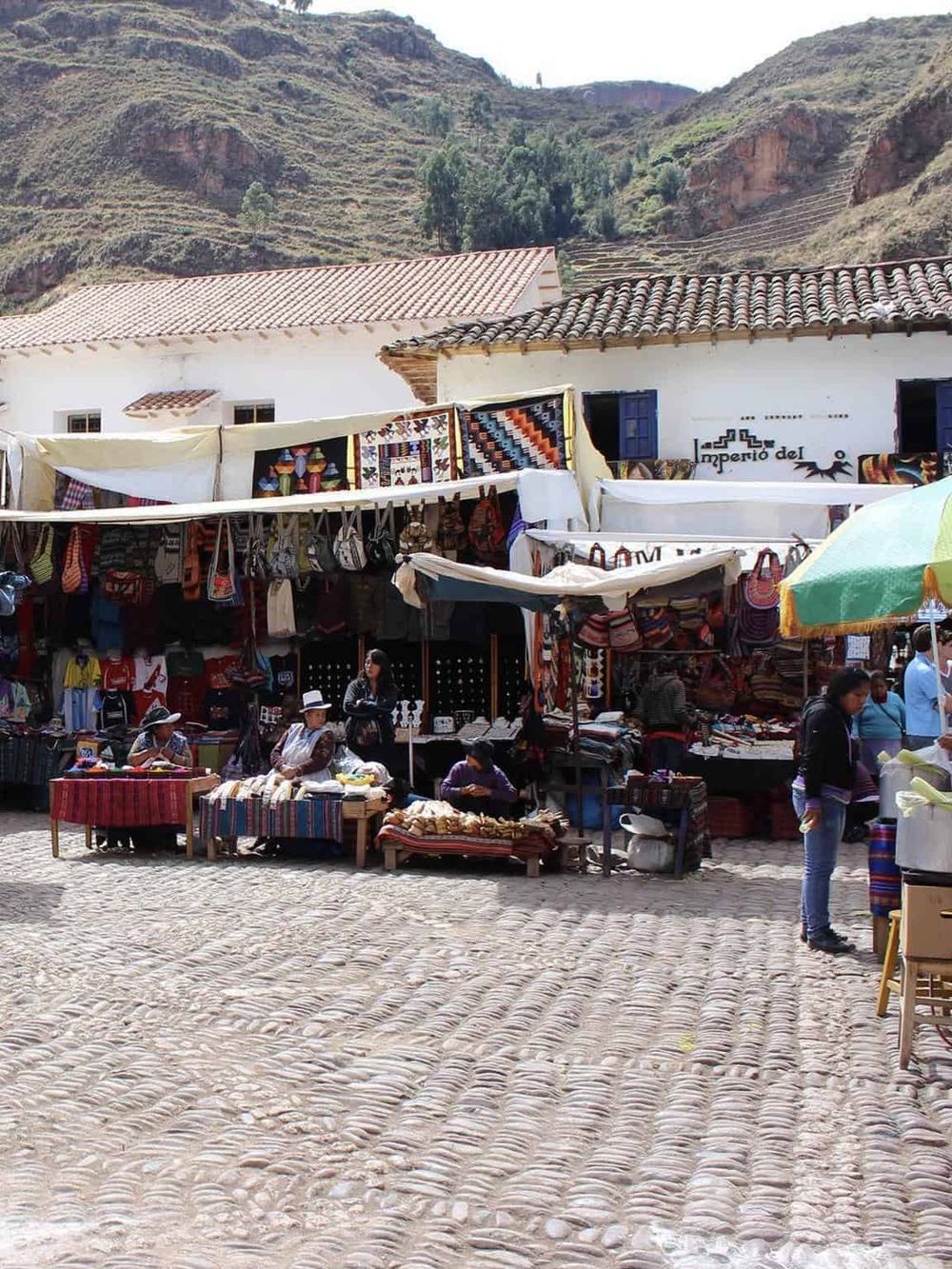 Colorful local market in Ollantaytambo, Peru with traditional crafts and textiles, capturing vibrant culture.
