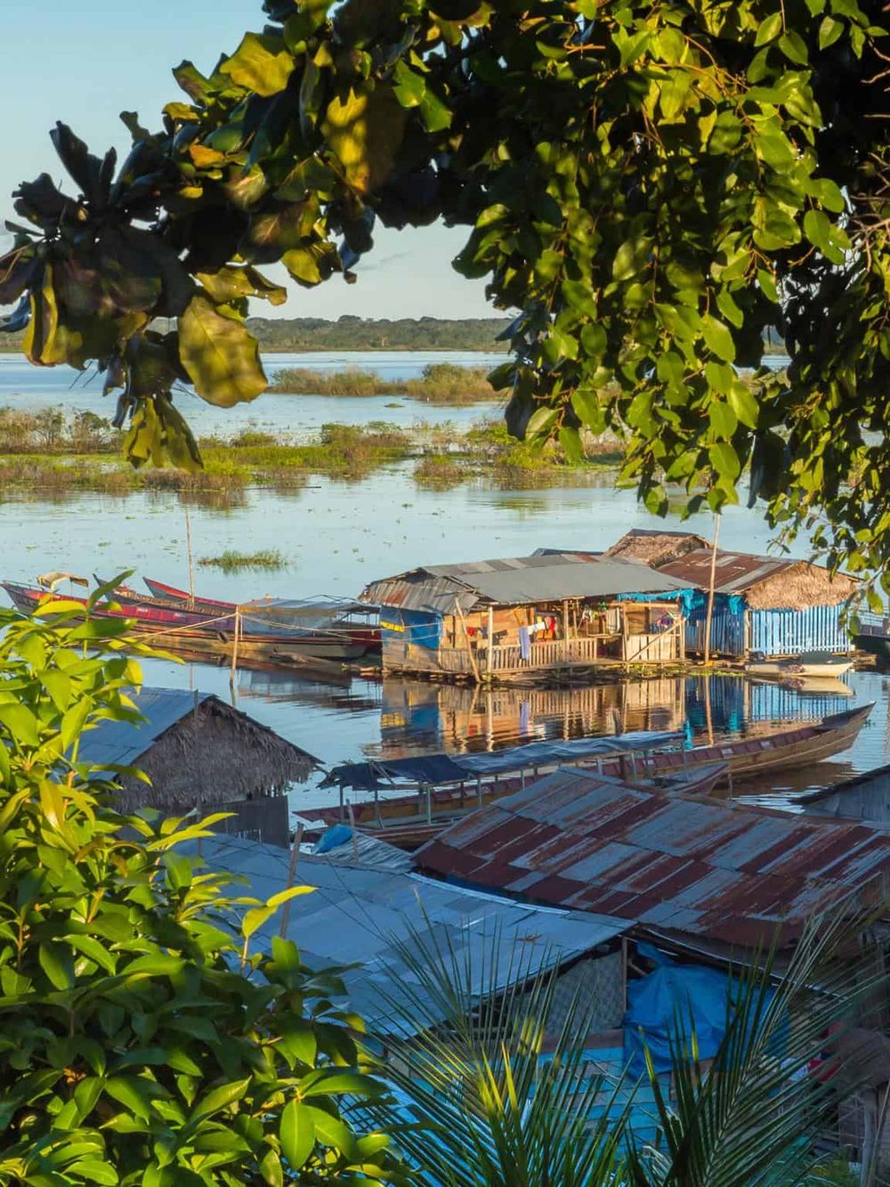 Boating village on a river with floating houses, lush greenery, and calm waters, showcasing a tranquil, scenic waterway.