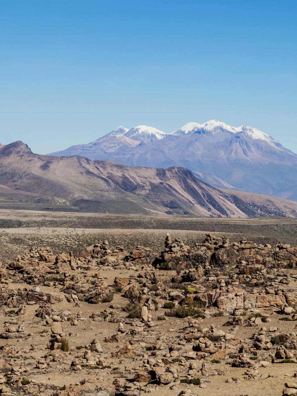 Snow-capped mountains and rocky desert landscape in New Zealand, showcasing breathtaking scenic views and adventure travel.