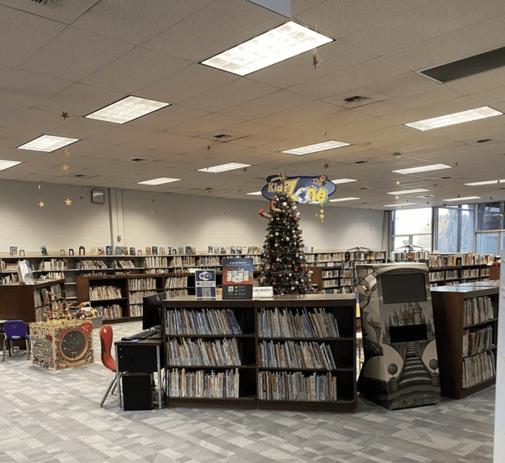 Colorful children’s bookshelf library decorated for Christmas with a Christmas tree, star ornaments, and festive decor.