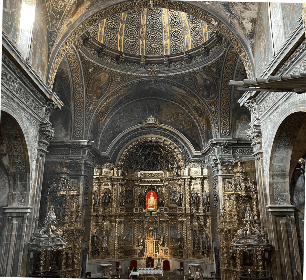 Intricate gold altar in a historic church with detailed baroque architecture and religious artwork.