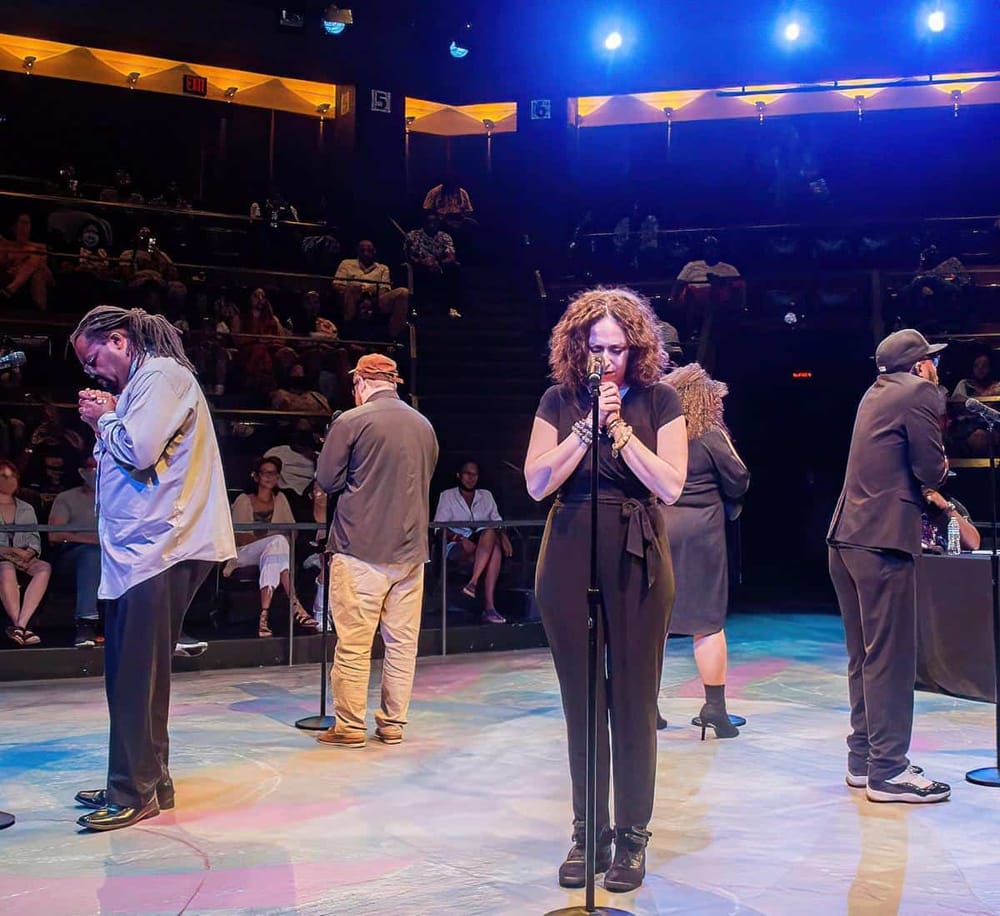 Soulful singer performing live on stage at QuestForDirections event.