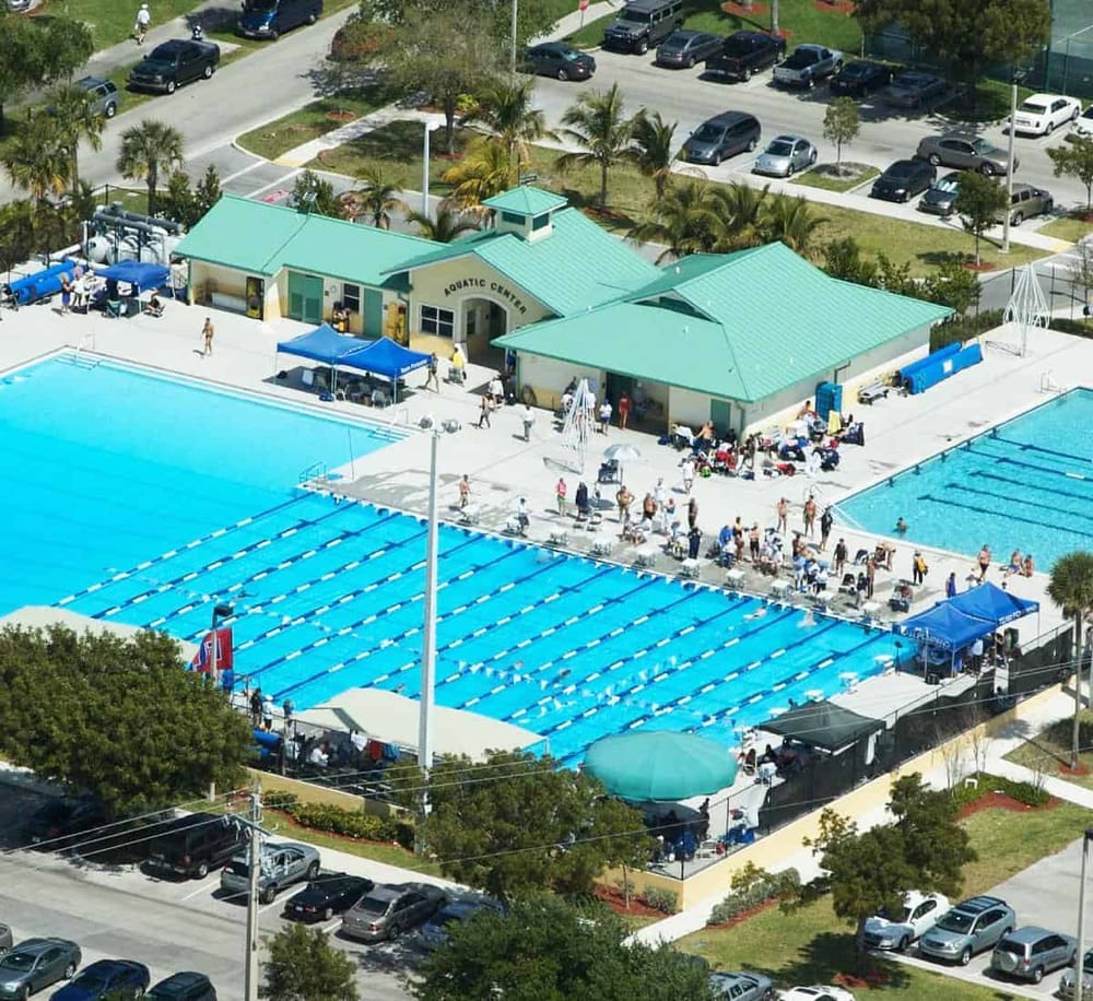 Indoor swimming pool and aquatic center at Quest for Directions, with visitors and shaded areas.