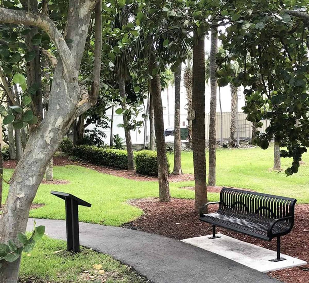 A peaceful park with benches, lush green grass, trees, and pathways ideal for relaxation and navigation.