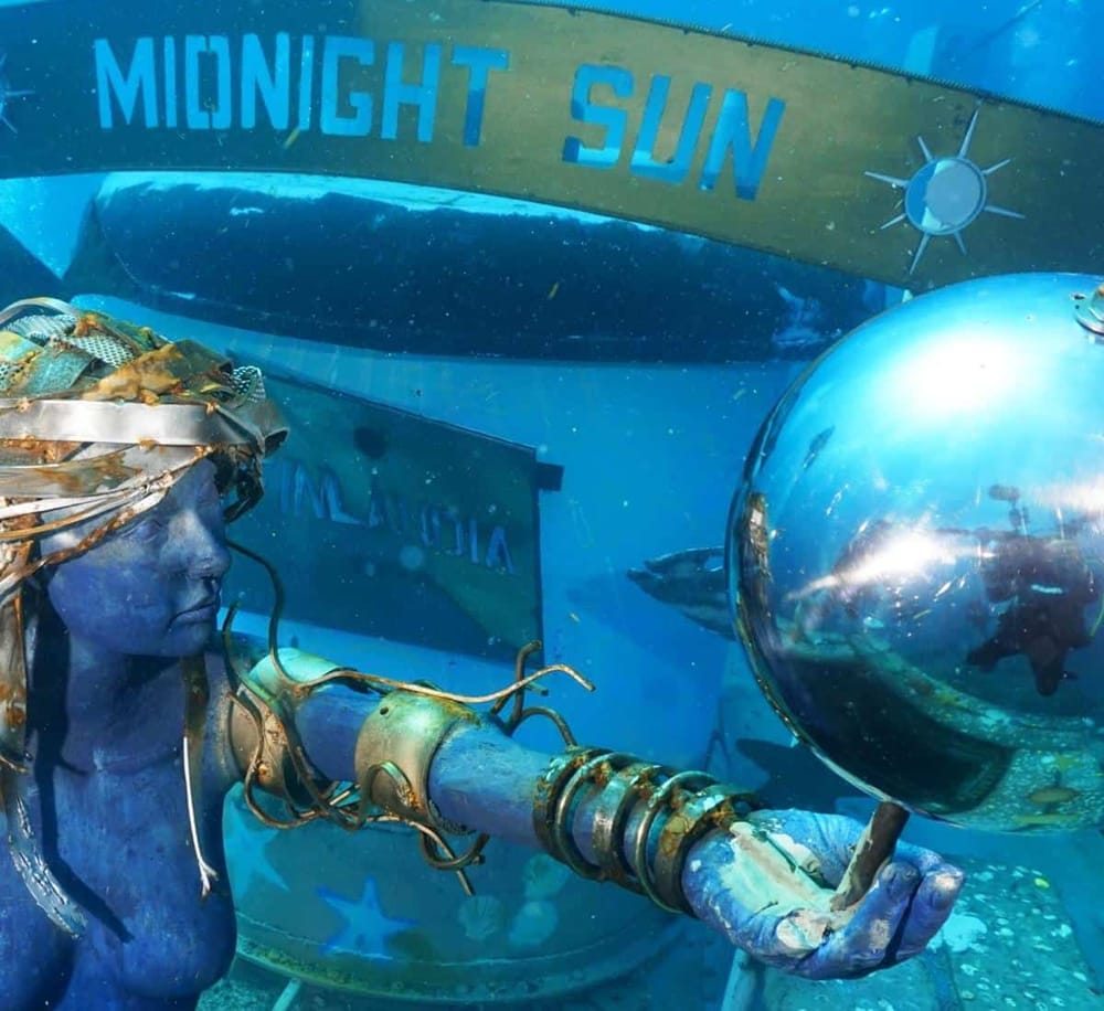 Underwater diver with steampunk helmet holding a lantern, "Midnight Sun" sign, scuba gear, exploring ocean depths.