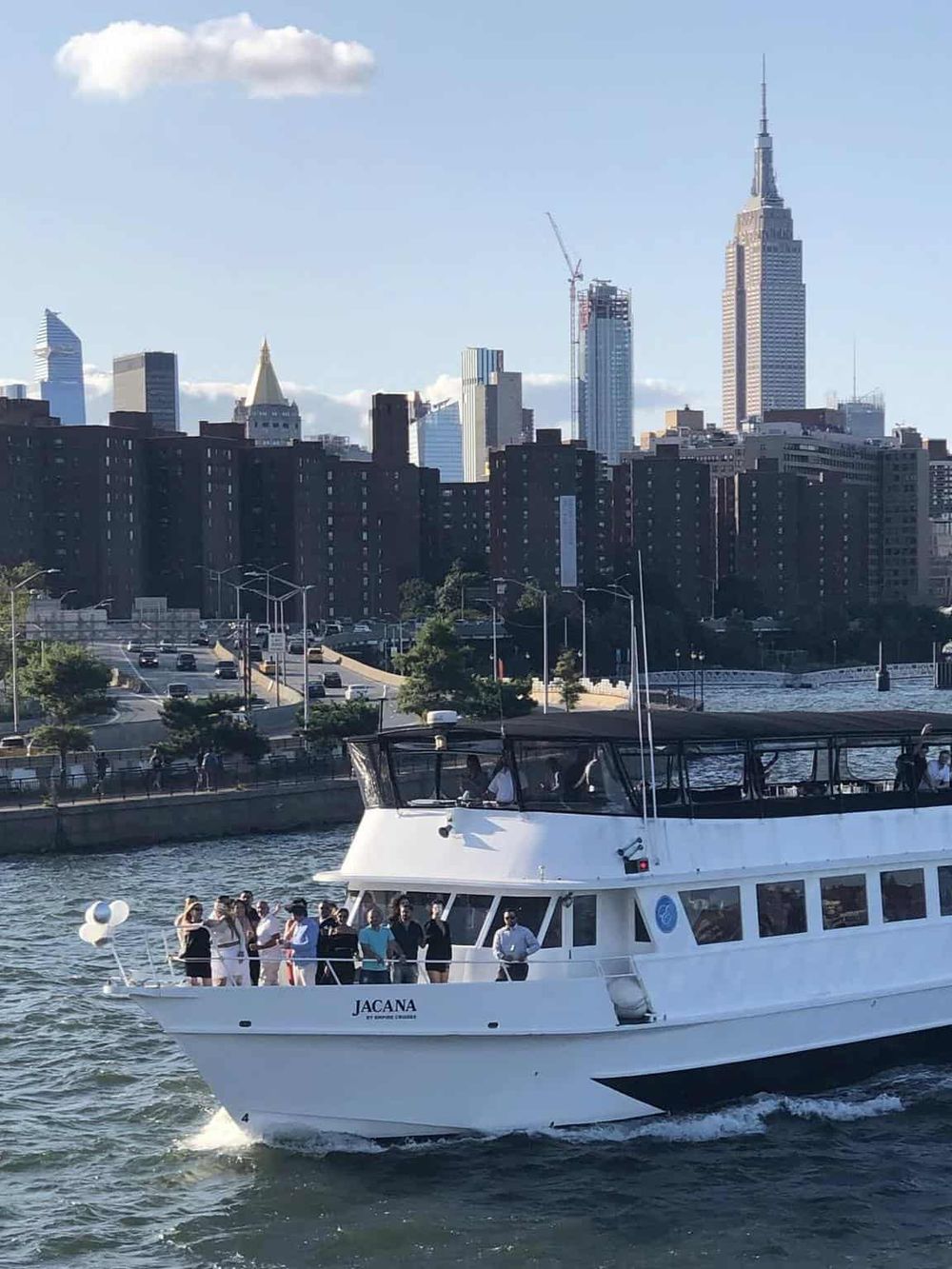 Boat cruise in New York City skyline with Empire State Building in the background.