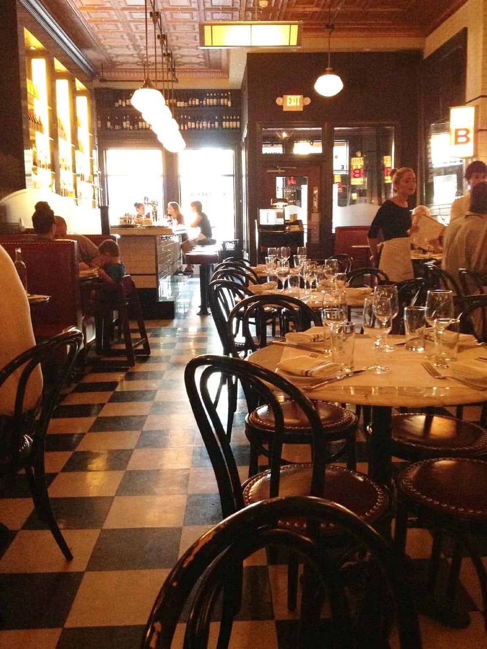 Cozy restaurant interior with elegant table settings, natural light, and a warm inviting atmosphere.