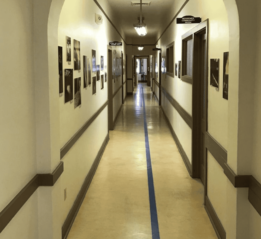 Vacant hospital corridor with artwork, guiding to community rooms and patient areas.