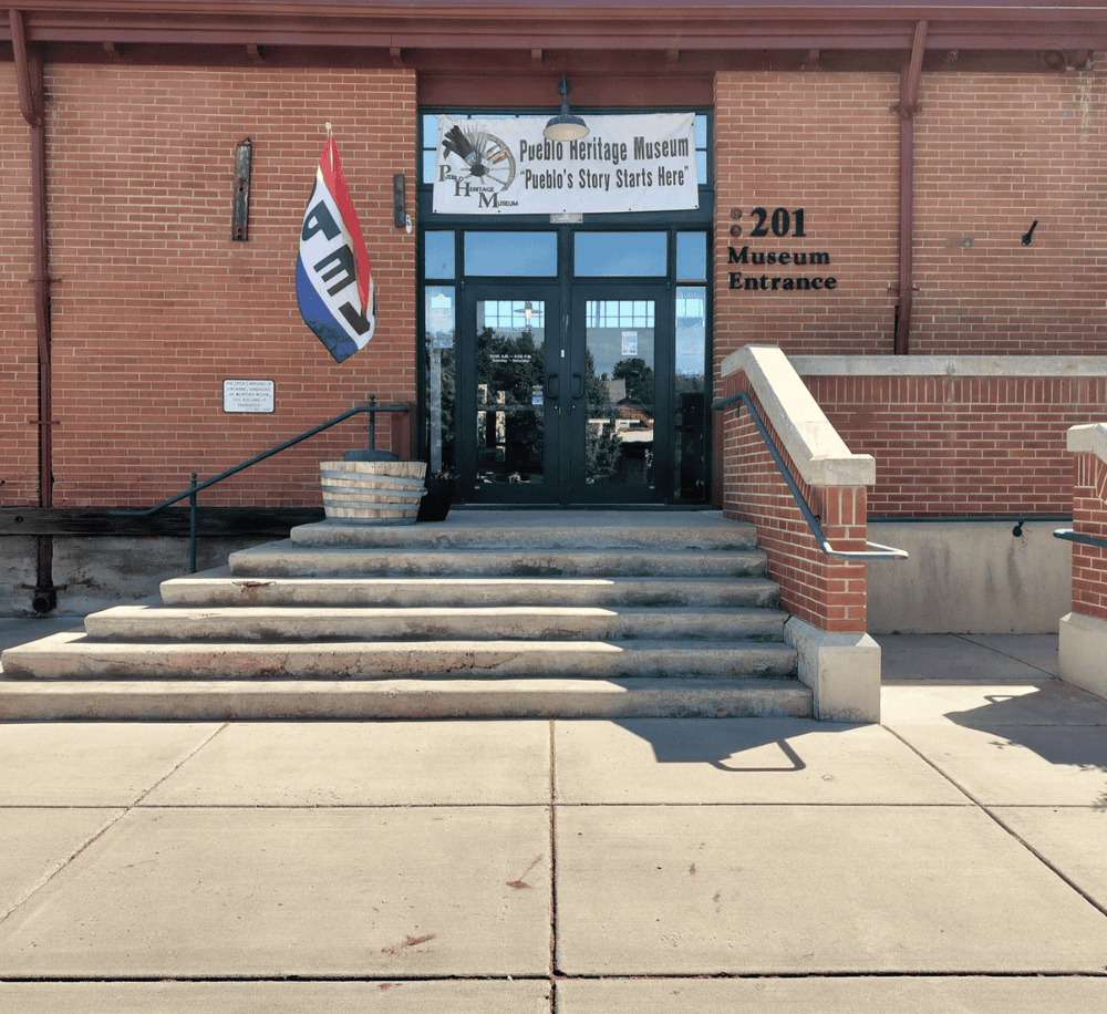 Colorful Pueblo Heritage Museum entrance with steps and signage, showcasing local culture and history.