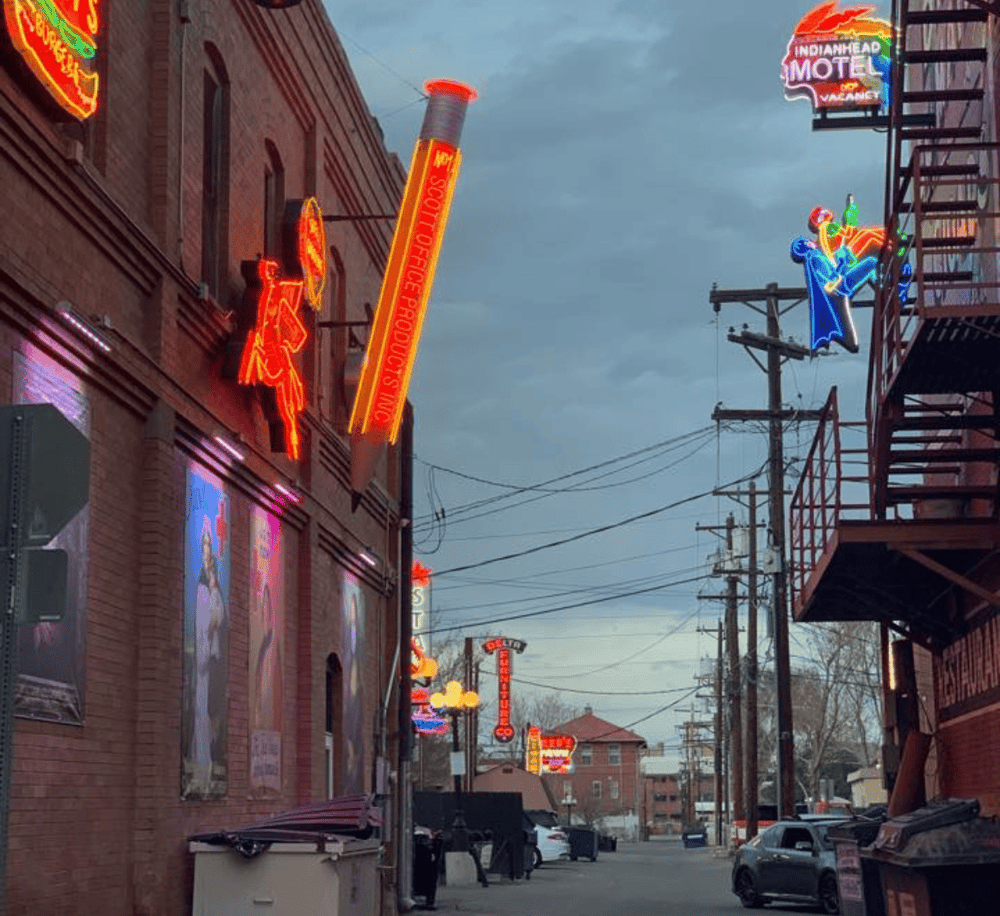 Neon signs on a lively street with restaurants and entertainment venues.