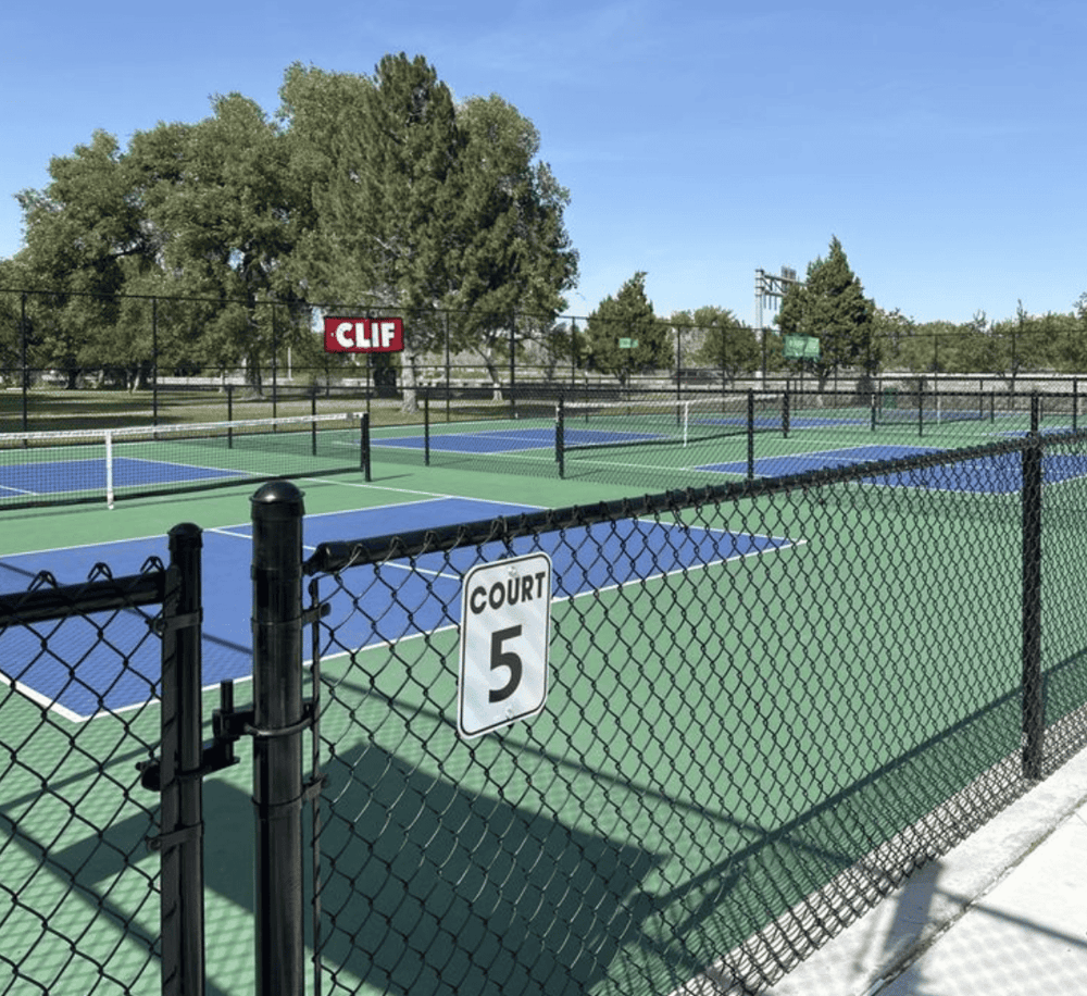 Tennis courts at QuestForDirections sporting complex, outdoor sports facility in a park setting.
