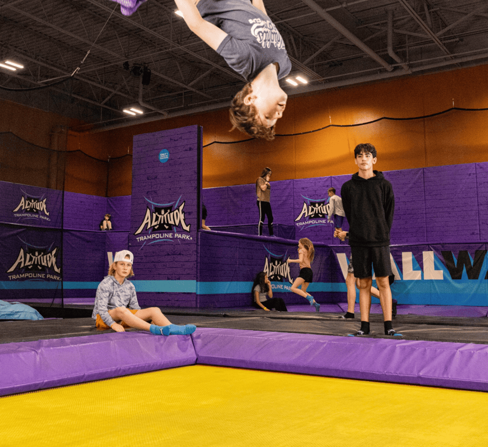 Jumping boy at trampoline park during indoor recreation.
