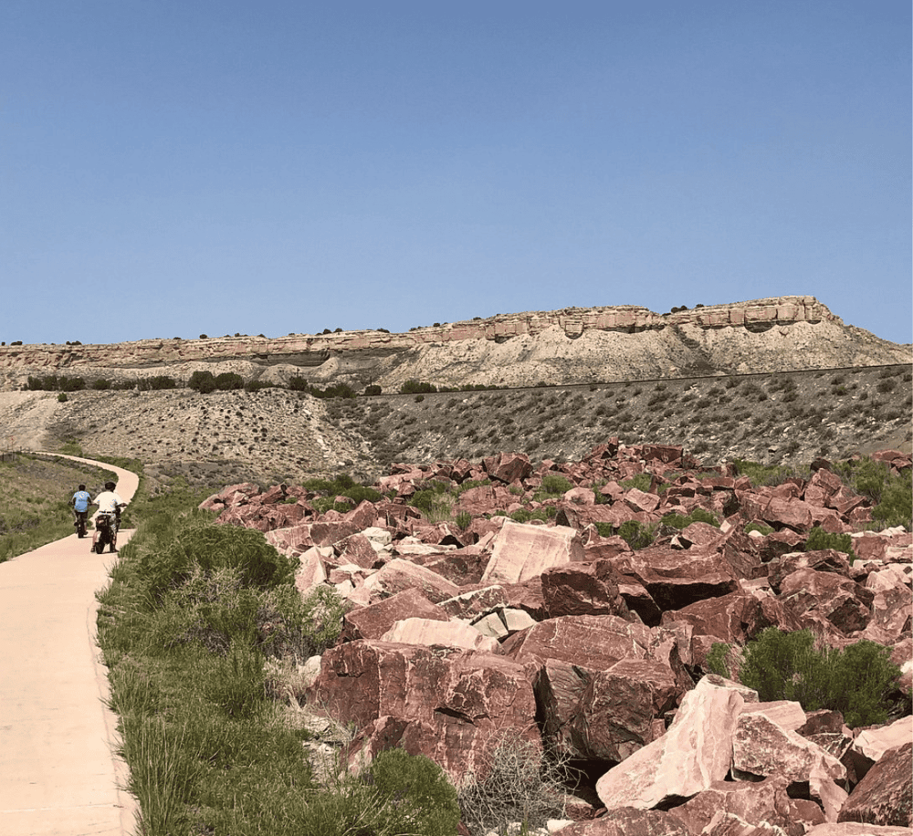 Rugged desert landscape with rock formations and hikers on trail, scenic exploration, QuestForDirections.