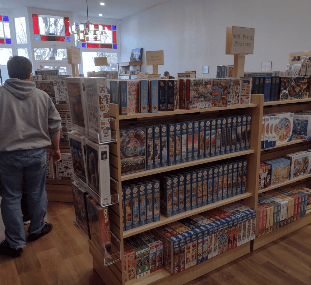 Puzzle store interior with diverse 1000-piece jigsaw puzzles for all ages.