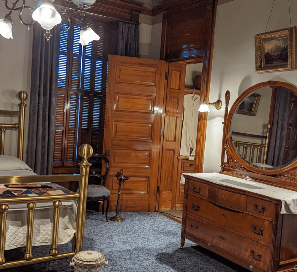 Victorian bedroom with antique wooden furniture and vintage decor, showcasing classic interior design.
