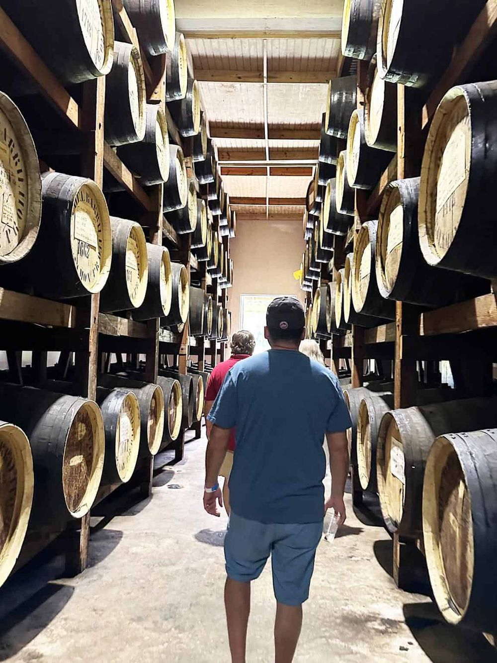 Vintage whiskey barrel storage in a distillery, showcasing traditional barrel aging process.