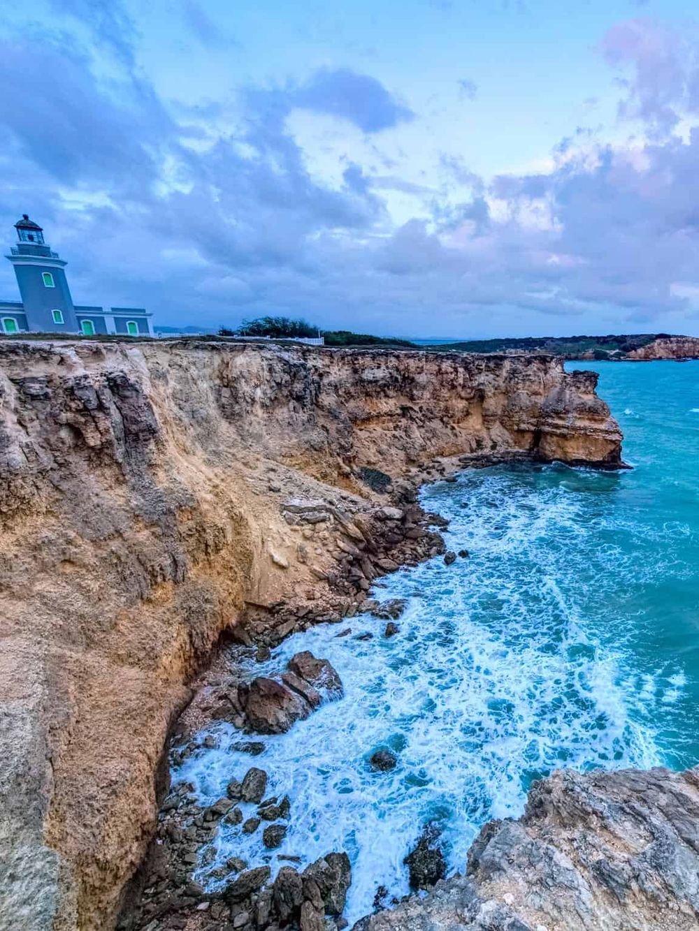 Seaside cliffs with lighthouse and ocean waves, scenic coastal view for travel and nature photography.