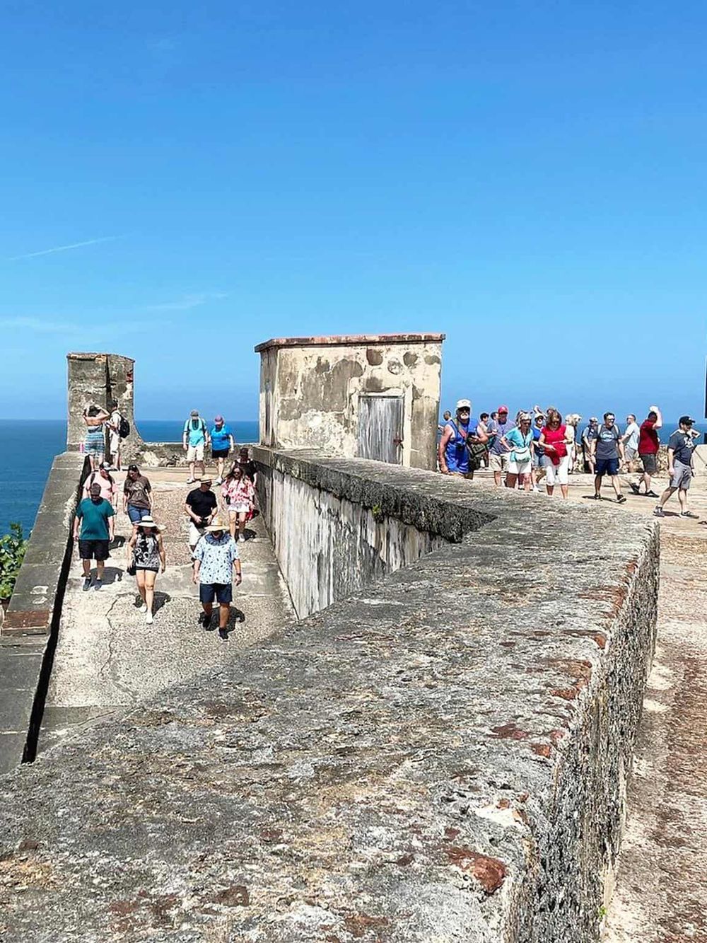 Historic fortress with tourists exploring scenic coastal views, part of Quest for Directions travel experience.